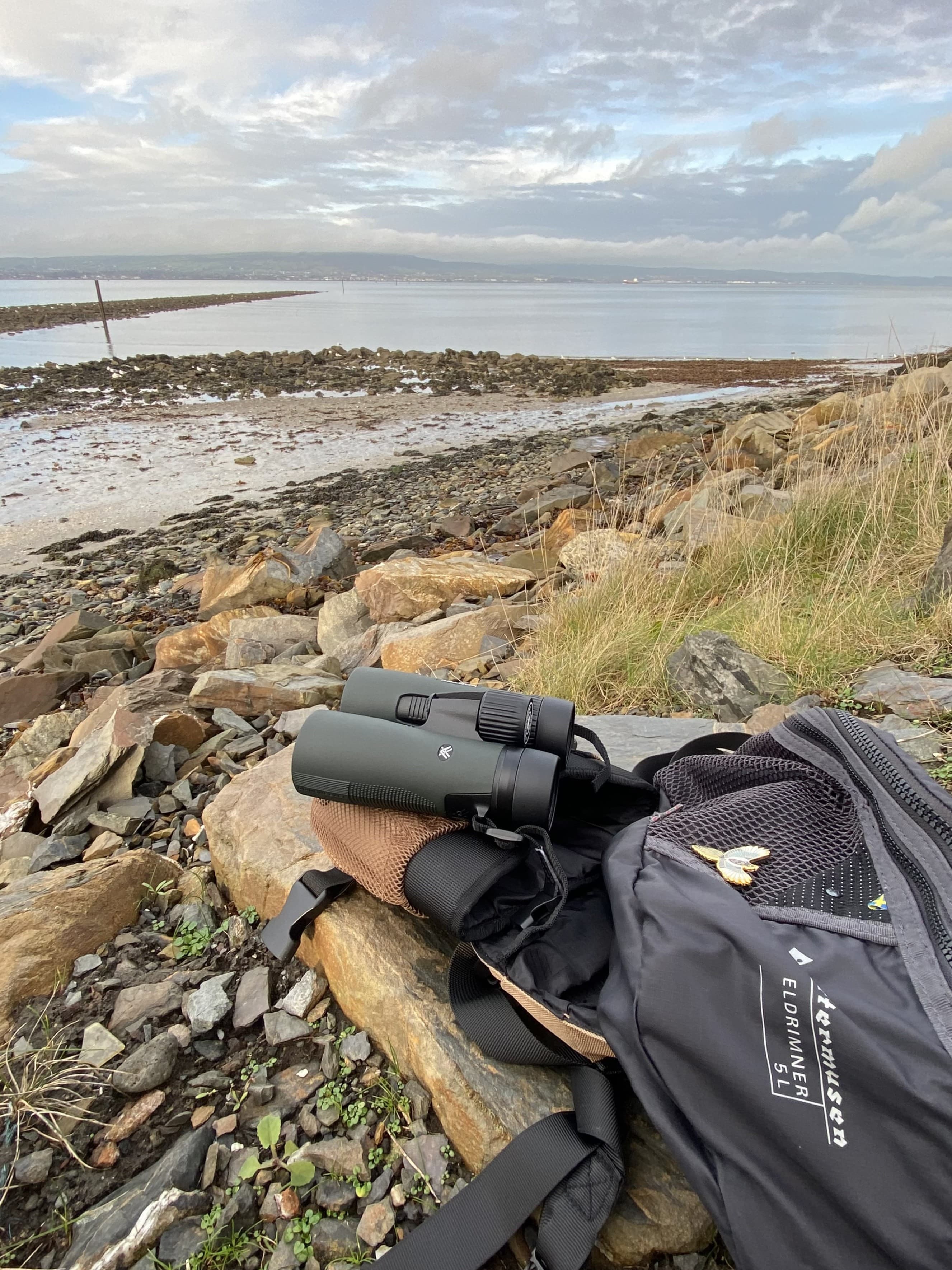 A pair of binoculars on a rock by the sea